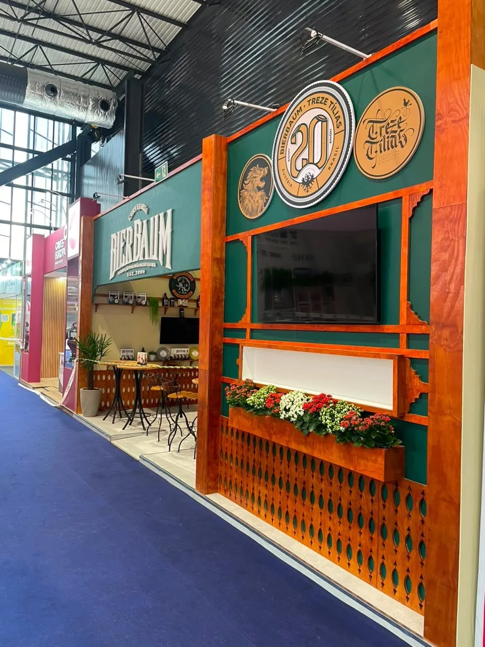 Fachada do stand Bierbaum com letras caixa e floreiras